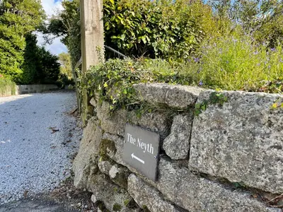 a stone wall with a sign that reads nice view at The Neyth in Budock Water