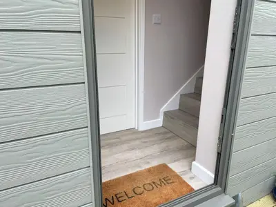 a door with a welcome mat in a hallway at The Neyth in Budock Water