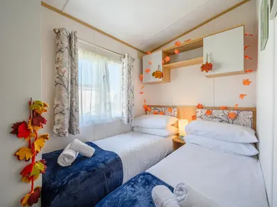 two beds in a small room with a window at Rose View in Newquay