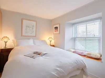 a bedroom with a large white bed and a window at Finest Retreats - West Cottage at Goldsithney in Perranuthnoe