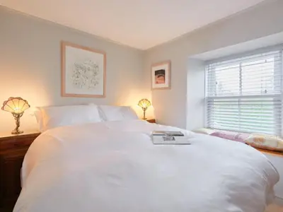 a bedroom with a large white bed and a window at Finest Retreats - West Cottage at Goldsithney in Perranuthnoe