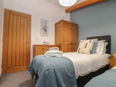 a bedroom with a bed with a wooden headboard at Tolcarne in Truro