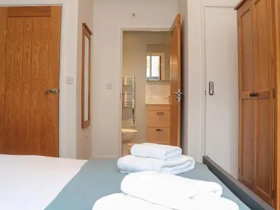 a bedroom with a bed with three towels on it at Tolcarne in Truro