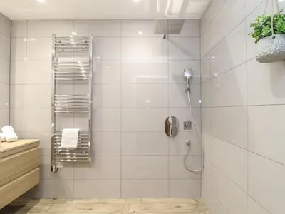 a bathroom with a shower with white tiles at Tolcarne in Truro