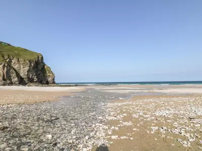 a beach with rocks and the ocean in the background at Tolcarne in Truro