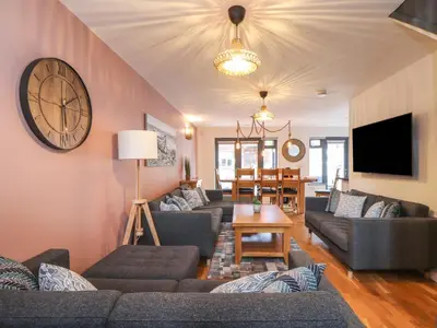 a living room with couches and a clock on the wall at Tolcarne in Truro
