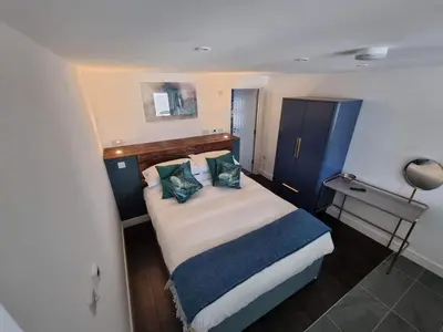 a small bedroom with a large bed with pillows at Chy Mor Apartment 1 in St Ives