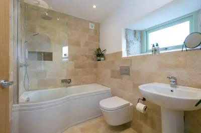 a bathroom with a sink and a toilet and a bath tub at The Reading Room in Falmouth
