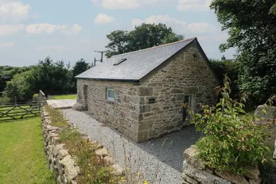 a small stone building with a stone wall at The Reading Room in Falmouth