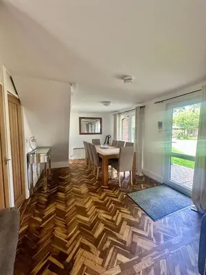 a dining room with a table and chairs on a wooden floor at Charming & Spacious Holiday Home in Hayle
