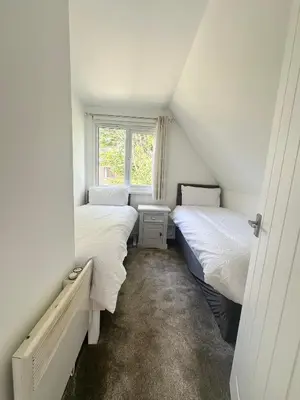 a attic bedroom with two beds and a window at Charming & Spacious Holiday Home in Hayle