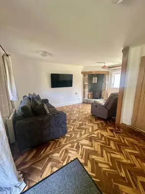 a living room with two couches and a flat screen tv at Charming & Spacious Holiday Home in Hayle
