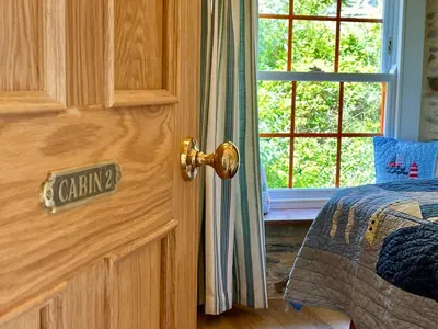 a door to a bedroom with a bed and a window at Unique Retreat - 2 bedroom cliff top cottage with large terrace in Portloe