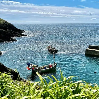 two boats in a large body of water at Unique Retreat - 2 bedroom cliff top cottage with large terrace in Portloe