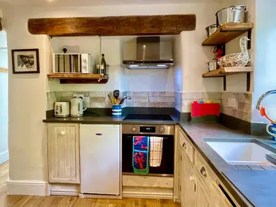 a kitchen with a stove and a sink at Unique Retreat - 2 bedroom cliff top cottage with large terrace in Portloe