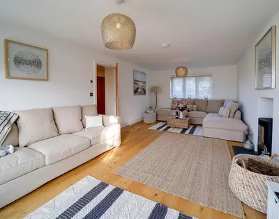 a living room with a white couch and a rug at Elmwood in Wadebridge