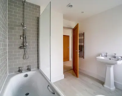 a bathroom with a bath tub and a sink at Elmwood in Wadebridge