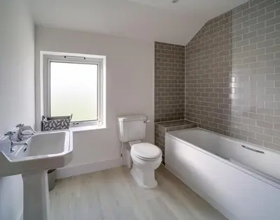 a bathroom with a toilet and a tub and a sink at Elmwood in Wadebridge