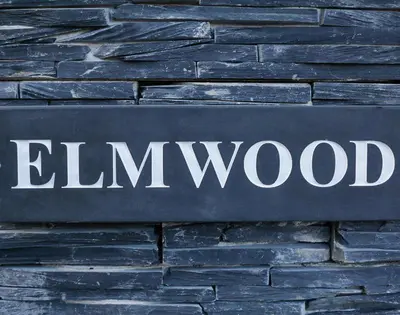 a sign for elim wood on a brick wall at Elmwood in Wadebridge