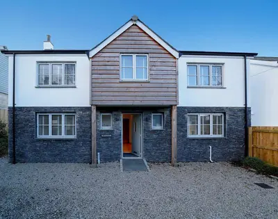 a large brick house with a door in a driveway at Elmwood in Wadebridge