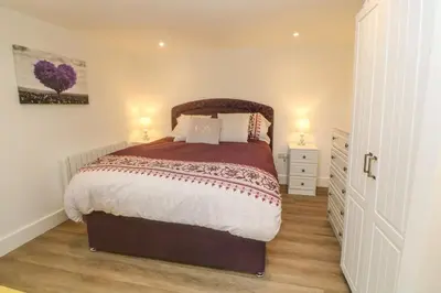 a bedroom with a large bed and two lamps at Perran Pearl B in Perranporth