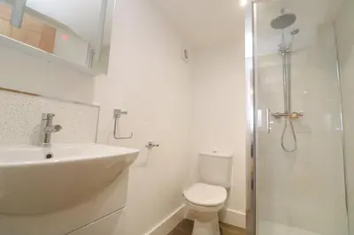 a bathroom with a toilet and a sink and a shower at Perran Pearl B in Perranporth