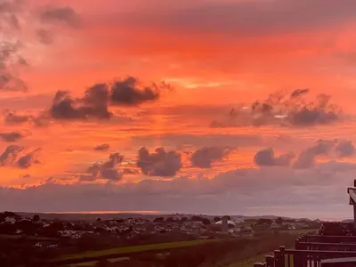 a sunset over a city with a cloudy sky at ELITE BLUE LUXURY 3 BEDROOM LODGE NEWQUAY, CORNWALL in Newquay