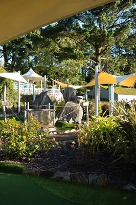 a garden with umbrellas and rocks and plants at ELITE BLUE LUXURY 3 BEDROOM LODGE NEWQUAY, CORNWALL in Newquay