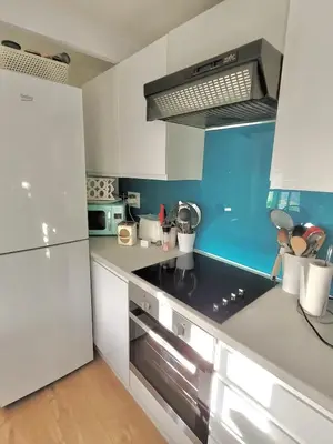 a kitchen with white cabinets and a blue wall at Idyllic Cornish Cottage, Superking bed, private garden dogs welcome in Truro