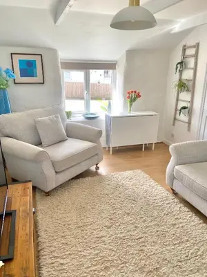 a living room with a couch and a chair at Idyllic Cornish Cottage, Superking bed, private garden dogs welcome in Truro
