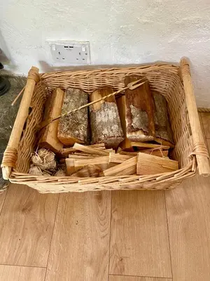 a basket filled with different types of bread on a floor at Romantic log-burner Cornish Cottage private garden dogs welcome in Truro