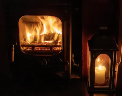 an oven with a fire in it with a candle at Romantic log-burner Cornish Cottage private garden dogs welcome in Truro