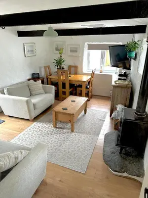 a living room with a couch and a table at Romantic log-burner Cornish Cottage private garden dogs welcome in Truro