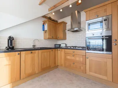 a kitchen with wooden cabinets and a stove top oven at Alfred Wallis in St Ives