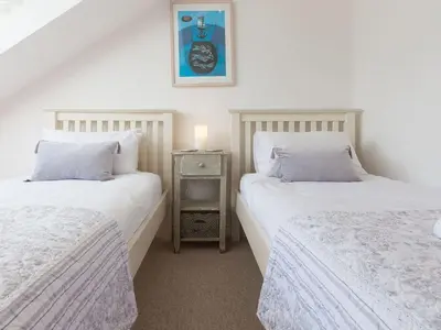 a bedroom with two beds and a table with a candle at Alfred Wallis in St Ives