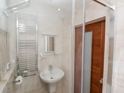 a bathroom with a sink and a toilet and a mirror at Heron in St Ives