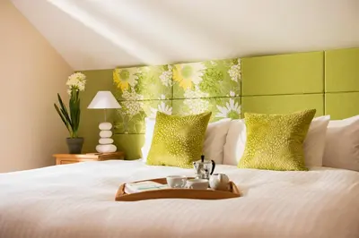 a bed with a tray with two cups on it at Herons House Sleeps 12, heated Pool, hot tub, sauna, games room 5 Star! in Saint Columb Major