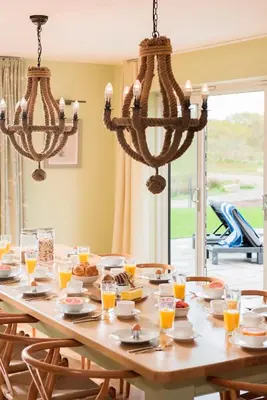 a dining room table with glasses of orange juice at Herons House Sleeps 12, heated Pool, hot tub, sauna, games room 5 Star! in Saint Columb Major