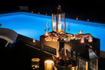 a table in front of a swimming pool at night at Herons House Sleeps 12, heated Pool, hot tub, sauna, games room 5 Star! in Saint Columb Major