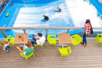 a group of people sitting at tables in front of a pool at Herons House Sleeps 12, heated Pool, hot tub, sauna, games room 5 Star! in Saint Columb Major