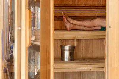 a persons feet in a wooden cupboard with a leg in it at Puffin Hot tub Lodge, 4 bedrooms Resort, Pool,Gym,Bar in Padstow