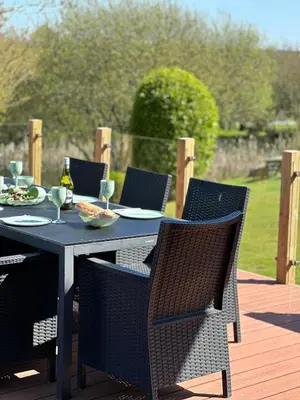 a table and chairs on a patio with food on it at Puffin Hot tub Lodge, 4 bedrooms Resort, Pool,Gym,Bar in Padstow