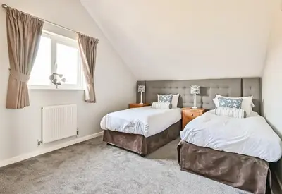a bedroom with two beds and a window at Swallow Lodge with Hot Tub, dogs welcome sleeps 8, Great resort Facilities in Padstow