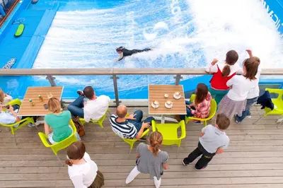 a group of people watching a person swimming in a pool at Waveside-Waterside with hot tubResort PoolGym in Padstow