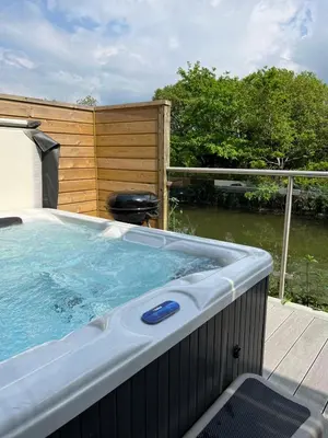 a jacuzzi tub sitting on top of a deck at Waveside-Waterside with hot tubResort PoolGym in Padstow