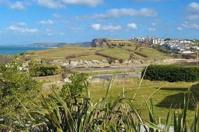a grassy hill with a city and the ocean at Tamarisk House in Newquay