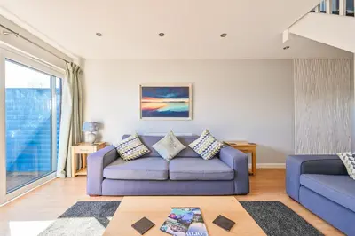 a living room with a purple couch and a window at SandPipers Luxury hot tub lodge with 2 ensuites a private Sauna & BBQ terrace in Saint Columb Major