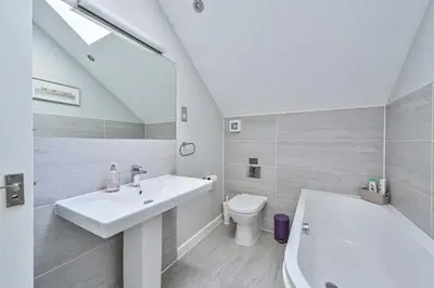 a white bathroom with a sink and a toilet at SandPipers Luxury hot tub lodge with 2 ensuites a private Sauna & BBQ terrace in Saint Columb Major