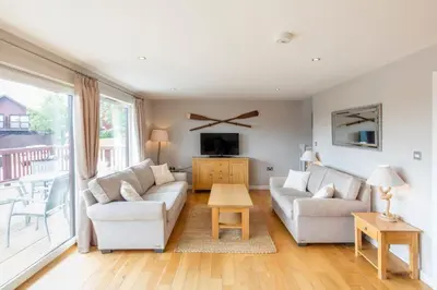 a living room with two couches and a tv at Retallack Resort 4 bedroom lodge - Hot Tub for hire on request -Pool & Spa in Padstow