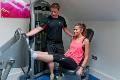a man helping a woman in a gym at Retallack Resort 4 bedroom lodge - Hot Tub for hire on request -Pool & Spa in Padstow